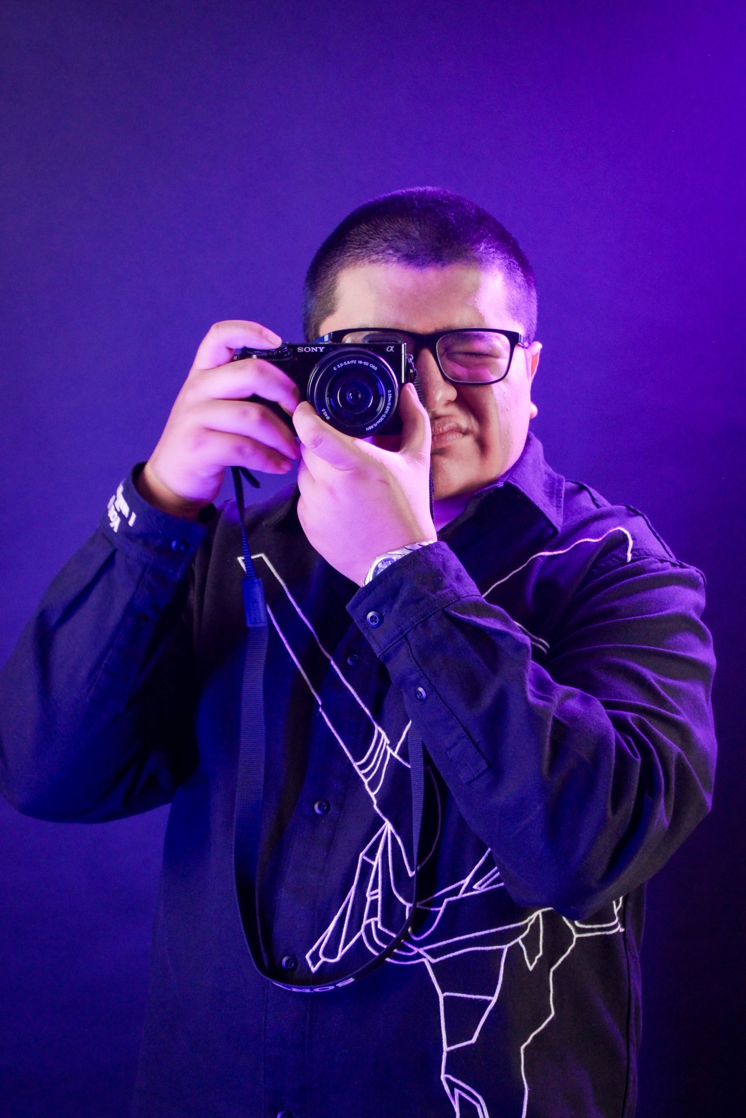 Diego Ixcaraguá con su cámara, en luz morada