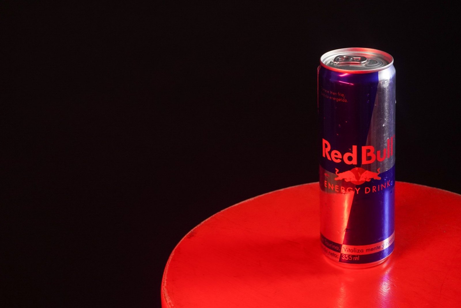 Lata de bebida energética sobre superficie roja
